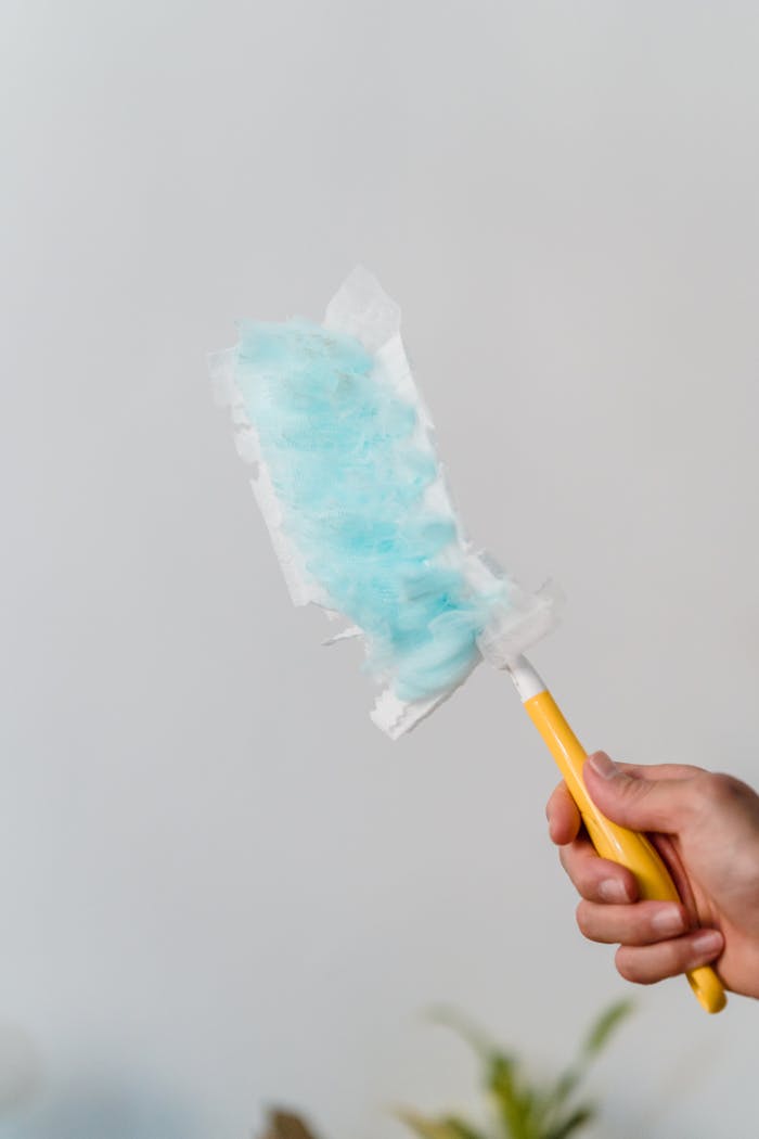 A close-up of a hand using a Swiffer for indoor cleaning, showcasing cleanliness and efficiency.